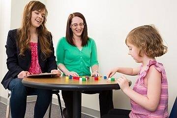 Trainee and school psychologist observing child playing